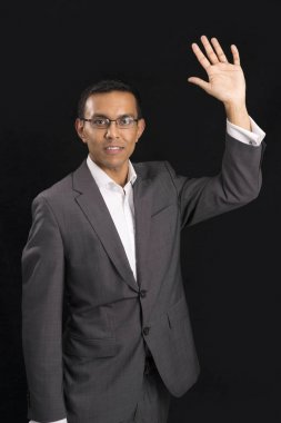 Genç adam yükselterek veya sol elinde sallayarak ofis kıyafet