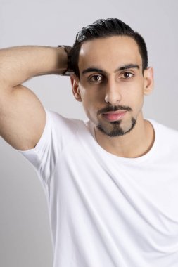 Saç geri iterek gri arka plan üzerinde Beyaz gömlekli genç adam