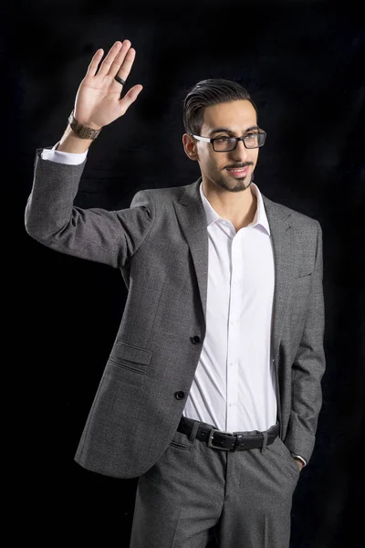 Ragazzo in elegante ufficio grigio Abbigliamento solleva la mano destra — Foto Stock