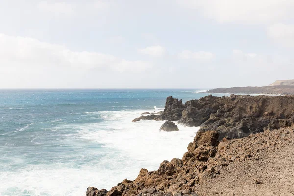 Вид вздовж узбережжя скельного утворення і моря з аварійними хвилями — стокове фото