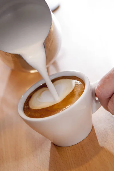 Ciepłe mleko lub śmietana napełnianie filiżanki espresso — Zdjęcie stockowe