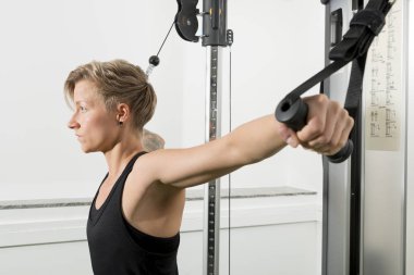 Atletik Bayan bir kablo makine çalışma dışarı yan görünüm