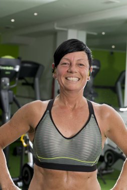 Kırpma üst peri saçlı kaslı esmer gülümser ve pozlar