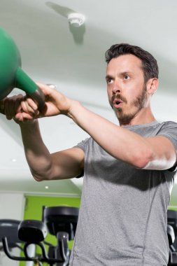 Atletik erkek yeşil Kettlebell kullanılarak çalışma
