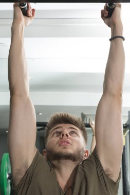 Genç adam üstünde-e doğru Pull-Up Bar salonunda kapma