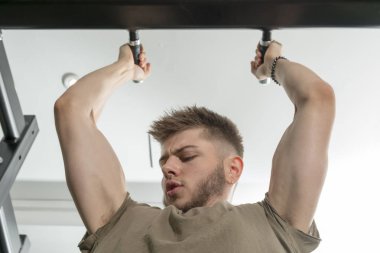 Pull-up gerçekleştirirken adam bakar, pazı