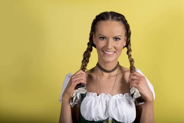 Porträtt av vacker flicka i Dirndl över gul bakgrund — Stockfoto