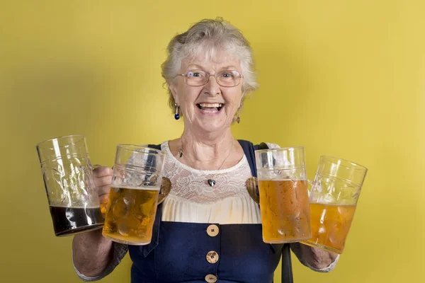 Gelukkig oude dame houdt van vier grote Crystal mokken met bier — Stockfoto