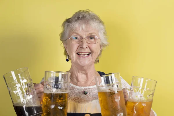 Rijpe dame houdt van vier grote Crystal mokken met bier — Stockfoto