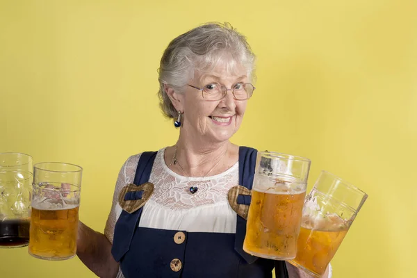 Lachende oude dame houdt van vier grote Crystal mokken met bier — Stockfoto