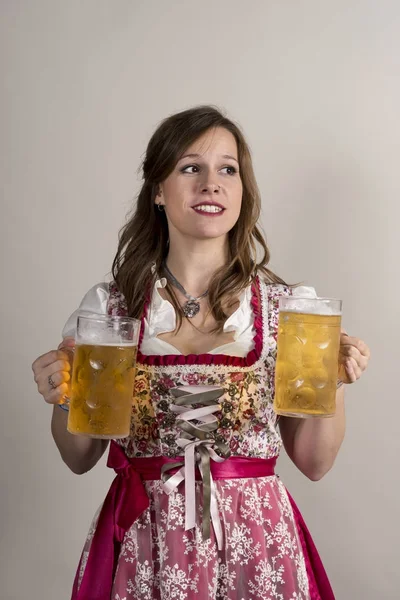 Frau im Dirndl mit riesigen Bierkrügen in jeder Hand — Stockfoto
