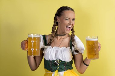 Göz kırpıyor ve bira dolu bardağı tutan Dirndl kız