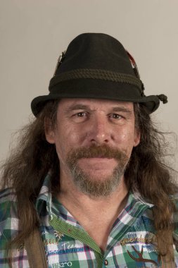 Şortlarla gri arka plan üzerinde uzun saçlı sakallı adam