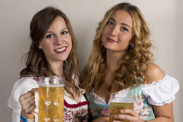 Twee meisjes in klederdracht Duitse met bier in de Hand — Stockfoto