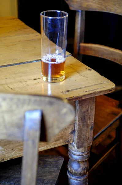 Cerveza en un vaso de vidrio en una mesa de cena antigua —  Fotos de Stock