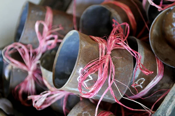 Boîtes de conserve rouillées enveloppées dans un nœud de ficelle rose — Photo