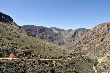 Dağ silsilesi güneşli mavi gökyüzü altında doğal görünümünü