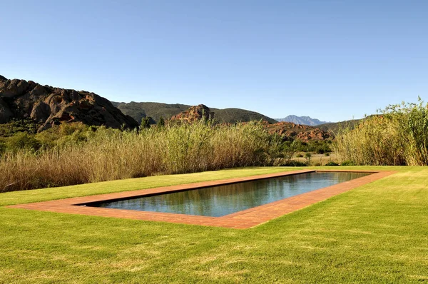 Brick Swimming Pool in Garden with View of Mountain Range