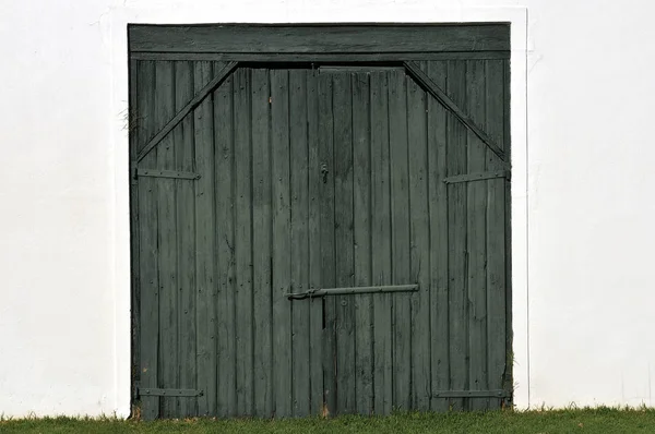 Porta de celeiro de madeira preta em uma parede branca — Fotografia de Stock