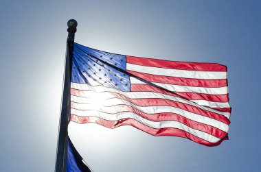 Mavi gökyüzü güneş kapsayan üzerine Amerikan bayrağı