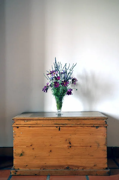 Vaso con fiori sul cassettone o sulla tavola in legno antico — Foto Stock