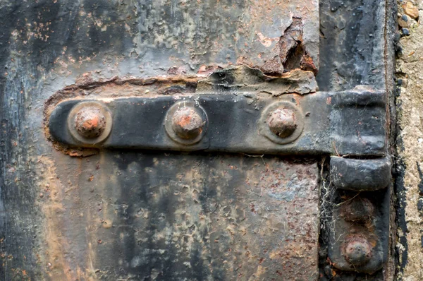 Fechar uma dobradiça em uma porta de ferro enferrujado — Fotografia de Stock