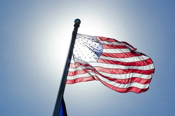 United States of America Flag Over Blue Sky Covering Sun