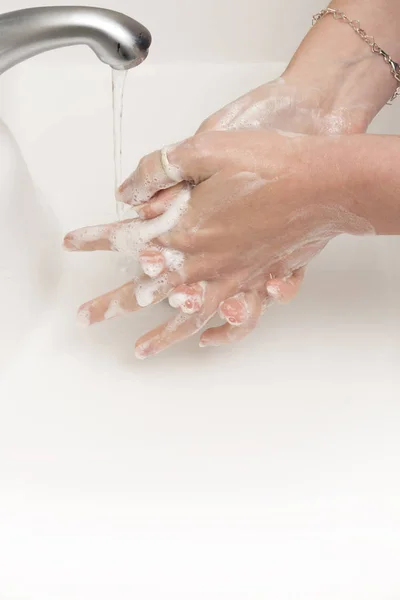 Мыльные руки промывают водой, текущей из крана — стоковое фото