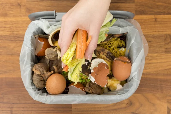 Overhead of Hand Colocando restos de comida en un cubo de basura — Foto de Stock