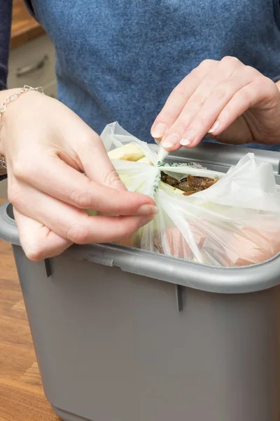 Sellar una bolsa de plástico llena de restos de comida en una papelera — Foto de Stock