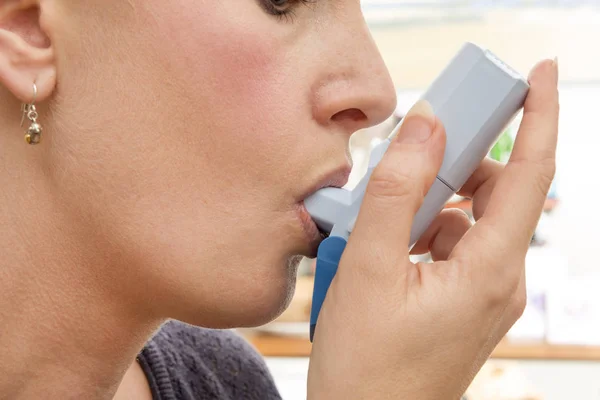 Mujer que usa medicamentos inhalatorios para ataques de alergia o asma — Foto de Stock