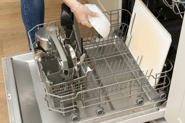 Mão de mulher colocando uma tigela na prateleira da máquina de lavar louça — Fotografia de Stock