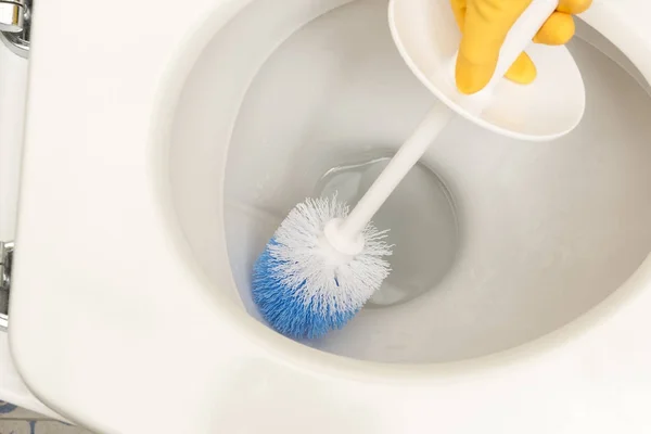 Amarelo luva mão escovação vaso sanitário Interior — Fotografia de Stock