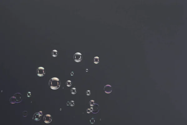 Stigande såpbubblor över en grå bakgrund — Stockfoto