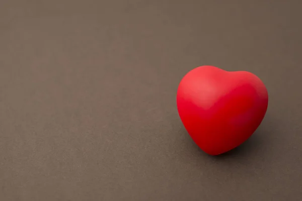 고독한 빨간 고무 심장 갈색 배경 복사 공간에 — 스톡 사진