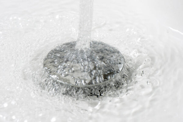 Вода стекает в ванну через отверстие для слива воды
