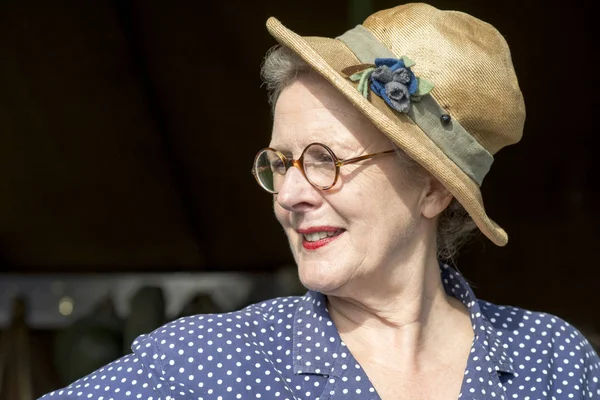 Sorrindo senhora vestindo chapéu velho e polka dot vestido azul — Fotografia de Stock