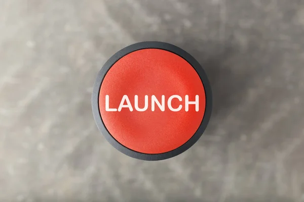 Overhead of Red Launch Push Button Over Blurred Gray Background