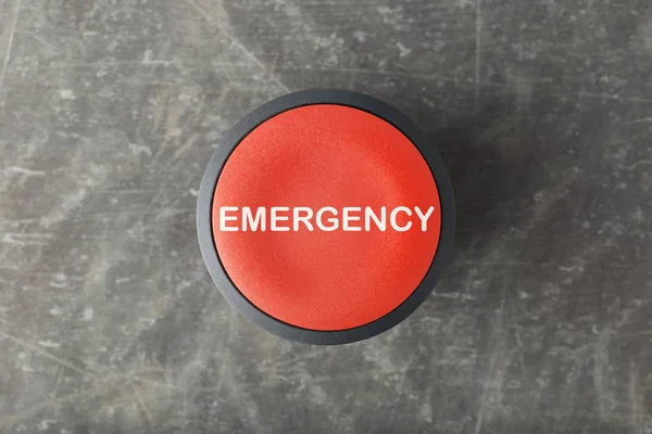 Overhead of Red \'Emergency\' Push Button on Concrete Background