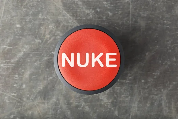 Overhead of Red \'Nuke\' Push Button on Concrete Background