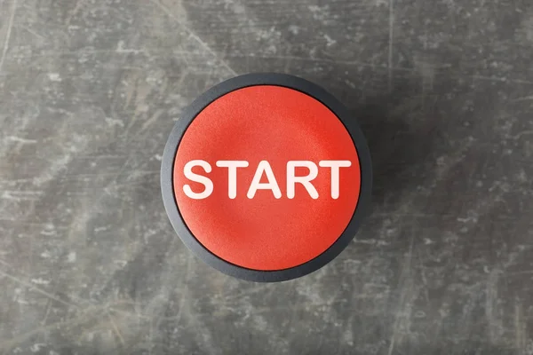 Overhead of Red Start Push Button on Concrete Background