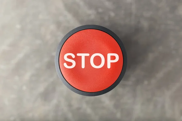 Overhead of Red \'Stop\' Button Over Blurred Gray Background