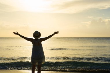 Siluet kadın, silah uzanmış Sunset Beach üzerinde karşı karşıya