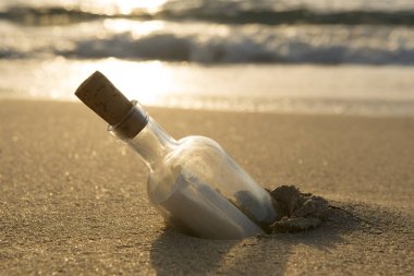 Not içinde ve yarı gömülü kum ile corked şişe