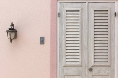 Ahşap kapı, kapı zili ve pembe duvar Sidelight