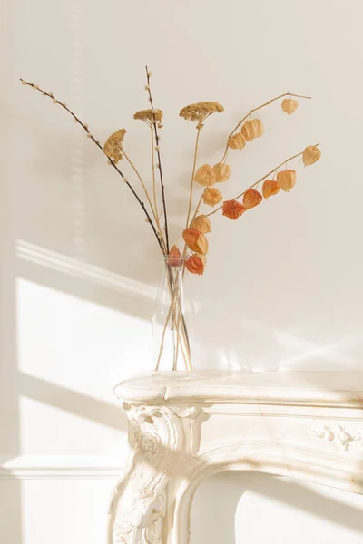 Jarrón de vidrio transparente con flores secas en la chimenea Mantel — Foto de Stock