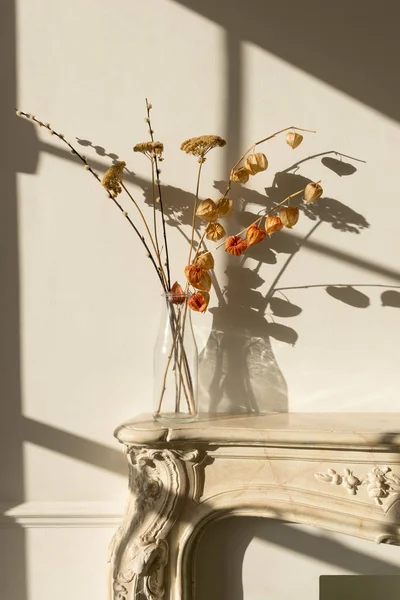 Clear Glass Vase on Sealed Fireplace Casting Shadow on Wall