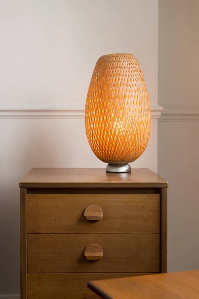 Holzschublade mit geflochtener Korbtischlampe oben — Stockfoto