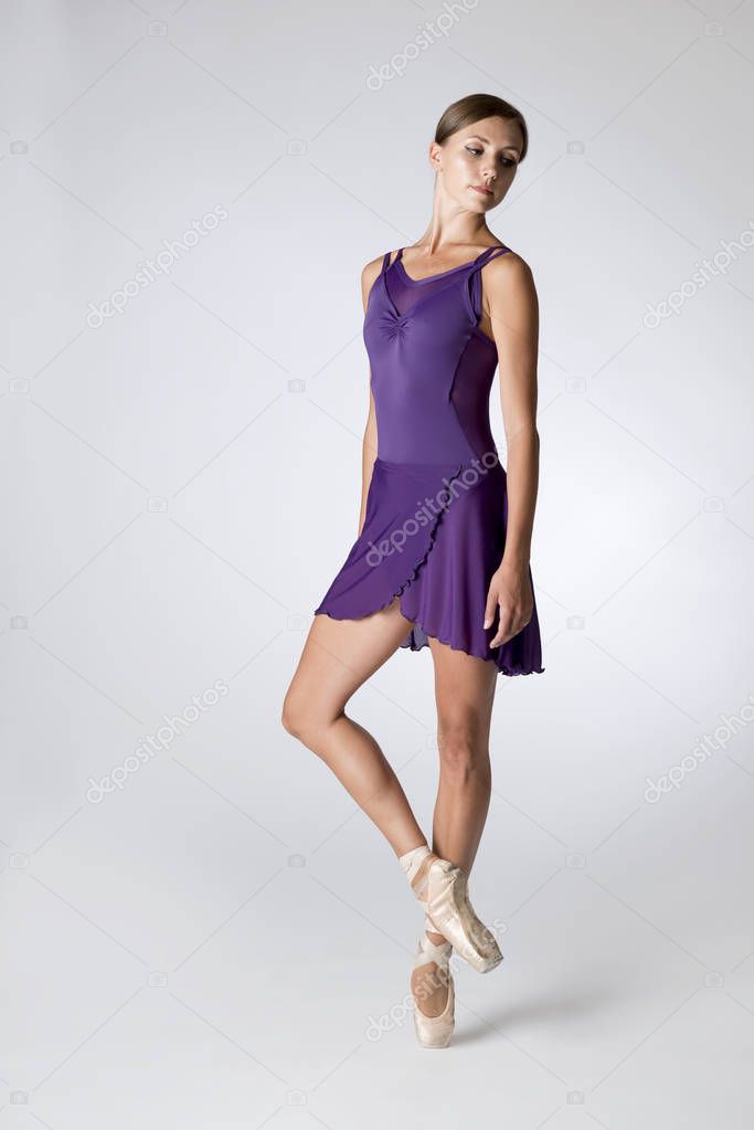 Ballerina Wearing A Purple Leotard Isolated in Gray Background