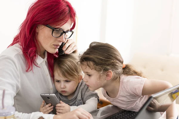 妇女与笔记本电脑通话时, 孩子们玩 Smartpho — 图库照片